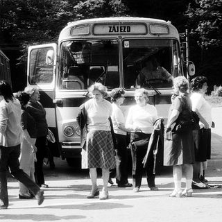 People boarding a bus labeled "Zajezo" in a bus station.