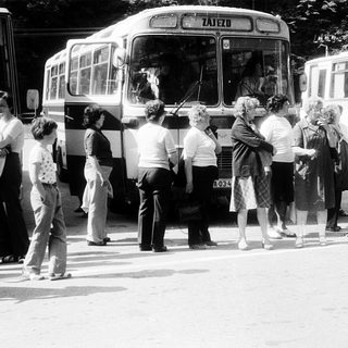 People boarding old-style buses labeled "Zajezd" in queue.
