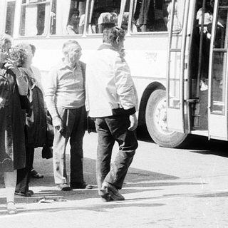 People boarding old-style buses labeled "Zajezd" in queue.