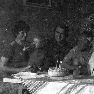 Vintage family celebrating birthday with cake.