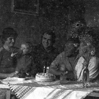 Vintage family celebrating birthday with cake.