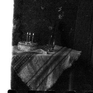 Birthday cake with four lit candles.