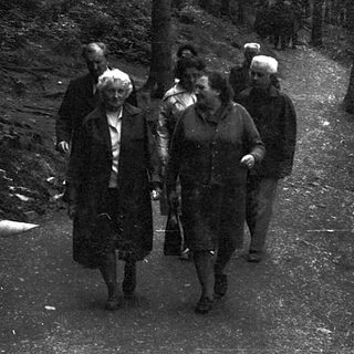 People walking together on a snowy forest path.