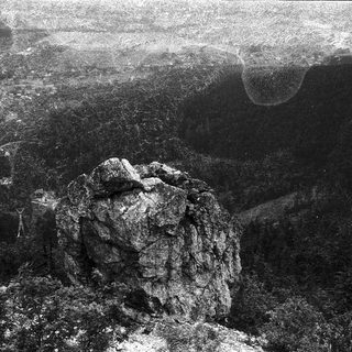 Large rock formation in volcanic or rugged terrain.