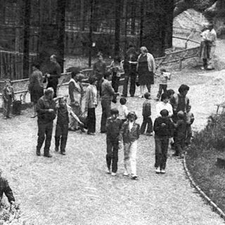 Historic mountain resort with vintage building and visitors.