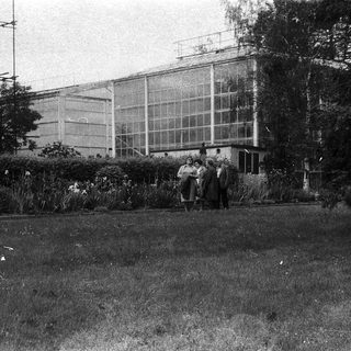 Large greenhouse with people standing outside.