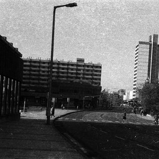 Urban street scene with mid-rise buildings and empty tracks.