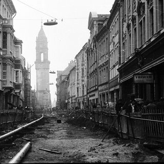 Bombed urban street with destroyed buildings and debris.