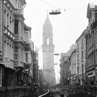 Bombed urban street with destroyed buildings and debris.