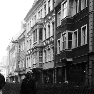 Rainy street scene with pedestrians holding umbrellas.
