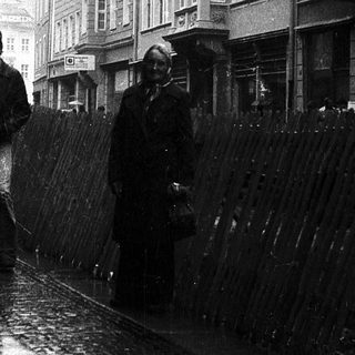 Rainy street scene with pedestrians holding umbrellas.