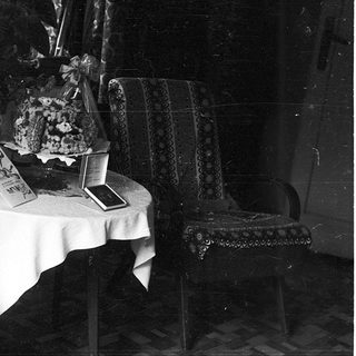 Vintage interior with table displaying cakes, books, and decorative items.