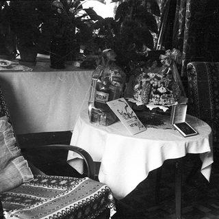 Vintage interior with table displaying cakes, books, and decorative items.