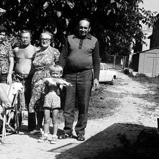 Family gathering outdoors in summer attire.