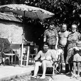 Family gathering outdoors in summer attire.