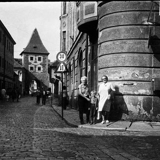 Historic European street scene with family near old buildings.