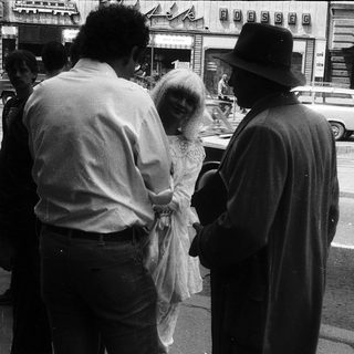 People on city street during wedding.