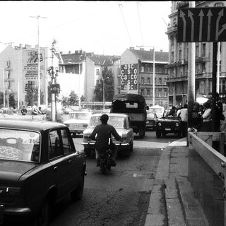 Busy urban street with traffic and pedestrians.