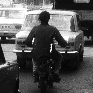 Busy urban street with traffic and pedestrians.