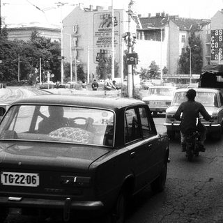 Busy urban street with traffic and pedestrians.