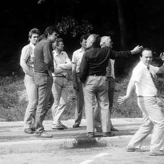 Group playing frisbee outdoors in casual attire.