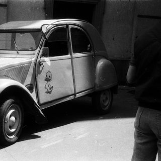 Classic Citroën 2CV with vintage decals parked.