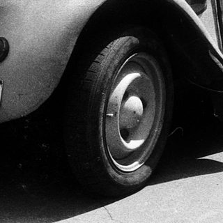 Classic Citroën 2CV with vintage decals parked.