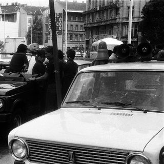 Police checkpoint with SUV and civilians stopped.