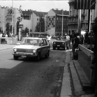 Urban street scene with police cars, crowd, and protest signs.
