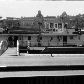 Ferry docked at Budapest with city skyline in background.
