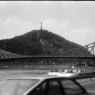 Historic bridge spanning river with mountain monument.