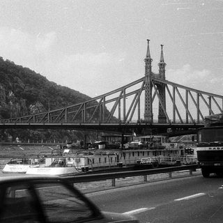 Historic bridge spanning river with mountain monument.