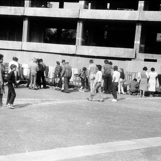 People queuing outside a building at night.