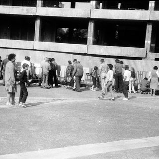 People queuing outside a building at night.