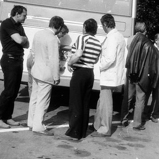 People queuing outside a bus at night.