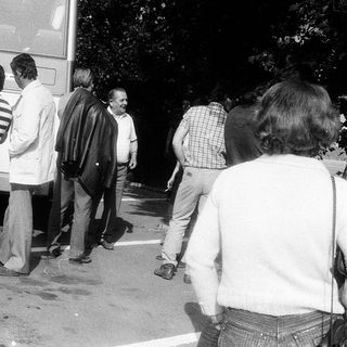 People queuing outside a bus at night.