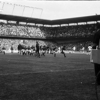 Black-and-white soccer match with live broadcast camera.