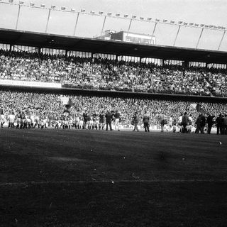 Massive stadium crowd during historic football match.