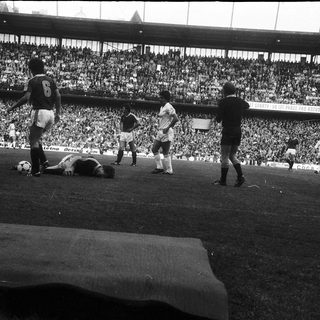 Classic soccer match with player injured on field.