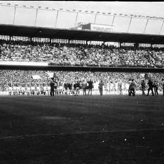 Massive stadium crowd during mid-20th-century football match.