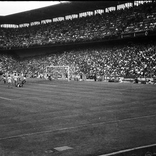 Black-and-white soccer match with packed stadium.
