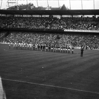 Pre-1980s stadium ceremony with large crowd.