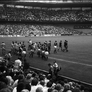 Pre-match team walkout on soccer pitch.