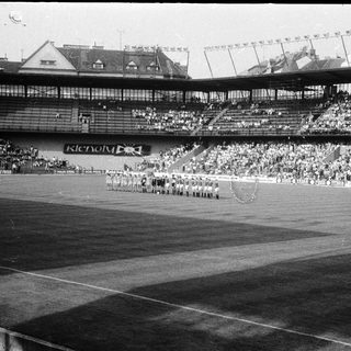 Pre-1960s stadium ceremony with large crowd.