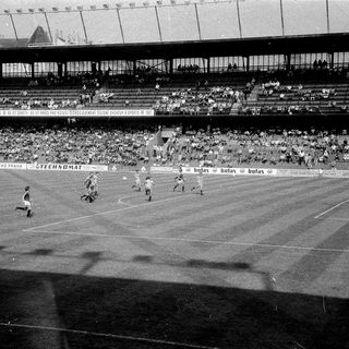 Classic soccer match in packed stadium.