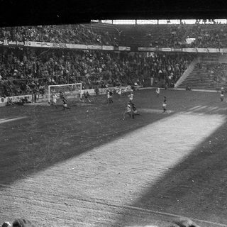 Black-and-white soccer match with crowd in stadium.