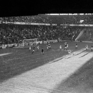 Black-and-white soccer match at packed stadium.