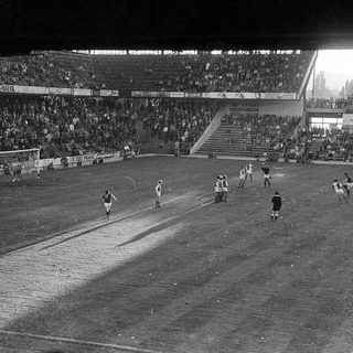 Black-and-white soccer match at packed stadium.
