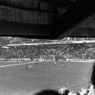 Black-and-white stadium football match in progress.