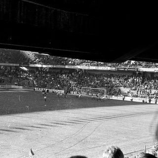 Football match in packed stadium.